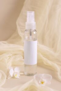 spray-refillable-bottle-near-orchid-flowers-and-tu-2025-03-13-11-59-39-utc